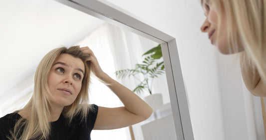 Femme regardant sa perte de cheveux dans un miroir