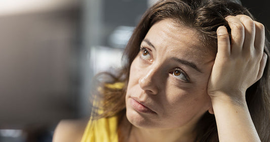 Femme stressée et angoissée regardant ses cheveux dans un miroir