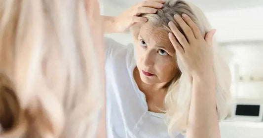 Femme avec perte de cheveux et problème de thyroïde se regardant dans le miroir
